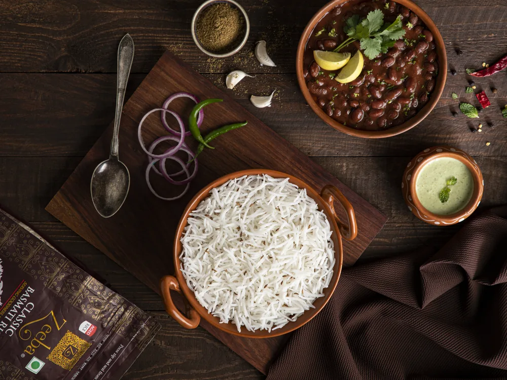 Pusa basmati rice in a dark bowl with a wooden spoon